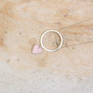 Un collier sautoir Valentine avec pendentif en cœur en porcelaine rose pâle , idéal comme cadeau élégant. Apprêts en argent pour une finition raffinée. Créations Blanc Couleurs