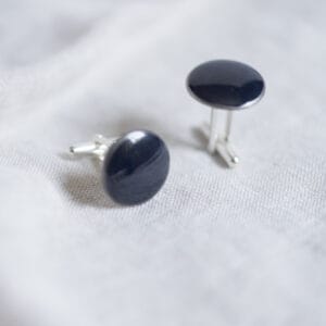 Détail de boutons de manchettes en porcelaine noir avec médaillons peints, filet en platine et montures en argent ou métal argenté, personnalisables sur demande – Créations Blanc Couleurs