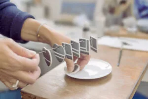 Aude Novikoff dans son atelier tenant les pièces en porcelaine peintes à la main