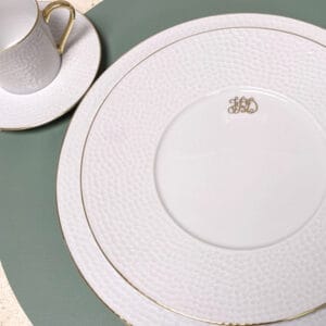 une assiette blanche et une tasse sur une surface verte