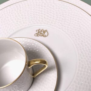 une assiette et une tasse blanches et dorées