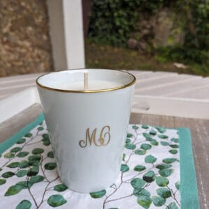 une bougie dans une tasse blanche sur une serviette