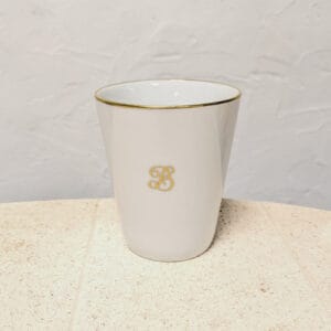une tasse blanche avec un bord doré