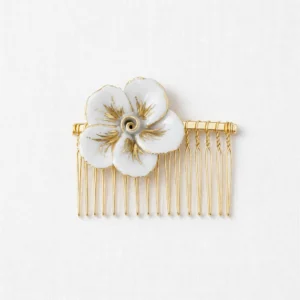 Le peigne de mariage Capucine est composé de e 1 fleur de camélia en porcelaine peintes à l'or, de feuillage en laiton doré et de perles pour une coiffure poétique.